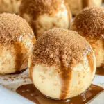 Creamy no-bake pumpkin pie cheesecake balls coated with graham cracker crumbs and white chocolate, served as a delicious fall dessert