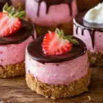 No-bake mini chocolate-covered strawberry cheesecakes, topped with fresh strawberries and white chocolate drizzle, perfect for parties or holidays.